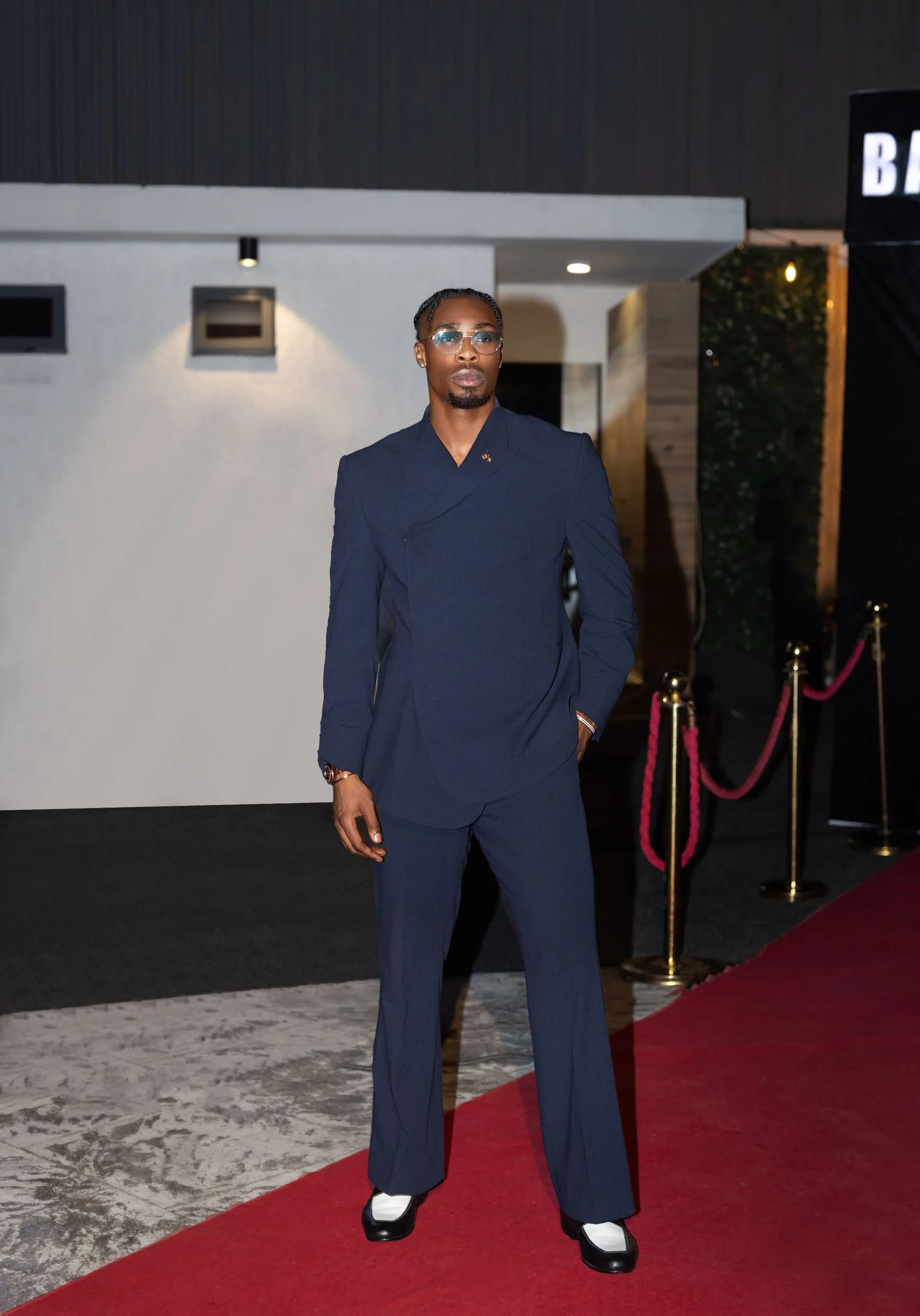 Formal guest arriving on a red carpet at a premium evening event.